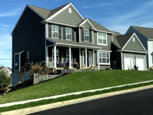 A beautiful newly built home with gray siding and white trim, showcasing quality construction by Lancaster Home Builders in Lancaster, PA.