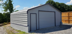 A newly constructed metal shed or garage with gray siding and a concrete block base by Walnut Bridge Construction in Knoxville, TN