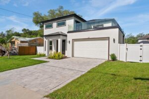 A newly built modern home exterior with a paved driveway by Coastal Pointe Homes, a general contractor in Tampa, FL.