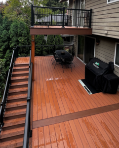 A newly built multi-level wooden deck with black railings and stairs by Rosas Construction and Renovation in Dallas, TX.