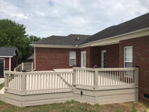A spacious, newly built outdoor deck attached to a brick home by Heritage Design & Remodel in Raleigh, NC.
