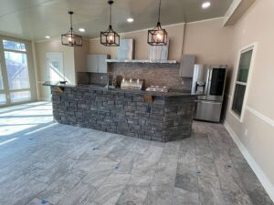 The interior of a newly built outdoor kitchen with a stone island by Four Seasons of River City in Columbus, GA.
