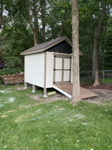 A newly built shed with a small wooden ramp in a backyard by Elde Contracting in Saint Paul, MN.
