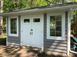 Newly built shed exterior with gray siding and white trim by Rochester Remodeling and Home Builders in Rochester, NY.