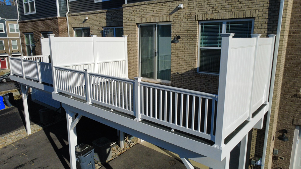 A newly built white composite deck with privacy panels by Pilgrim Decks and Fence LLC in Elkridge, MD.
