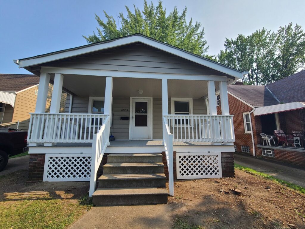 A newly built white front porch and railing completed by Indoor/Outdoor Home Repairs in Parma, OH.
