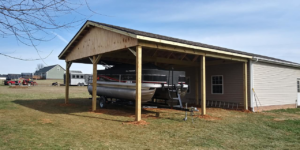 A newly constructed wooden carport or lean-to structure next to a building, built by Any Length Improvements in Bowling Green, KY.