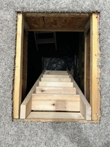 Newly built wooden stairs leading into a crawl space by Blue Heron Property Care LLC in Kalispell, MT