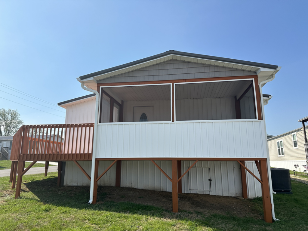 An exterior view of a house featuring a newly built wooden deck and screened porch by ACC Construction in Knoxville, TN.