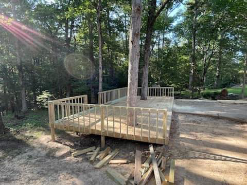 A newly built wooden deck around trees in a natural setting, an exterior service by Coburns interior and exterior in Services Available In.