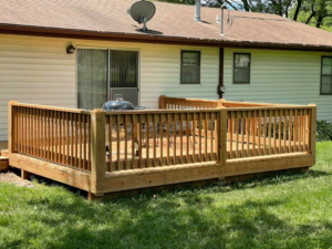 A newly built wooden deck with railings, constructed by Capital T's Home Specialty LLC in Topeka, KS.