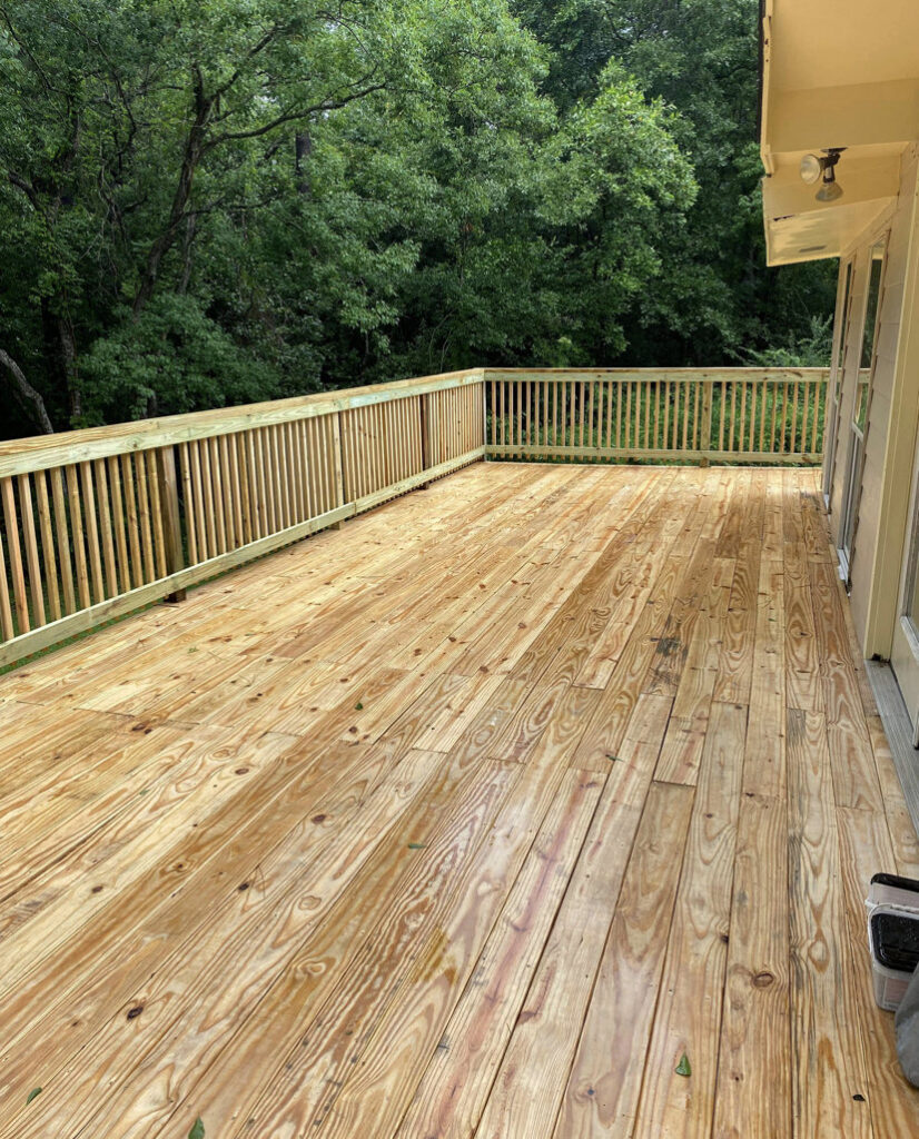 A newly constructed wooden deck with railings, showcasing quality craftsmanship by SMM Services LLC in Gulfport, MS.