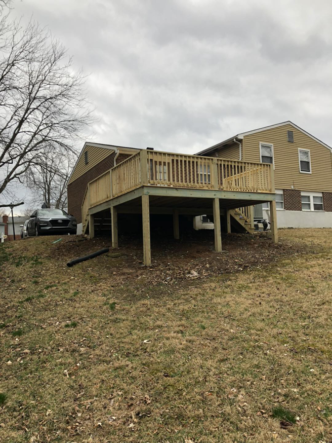 A newly built wooden deck addition attached to a house by Brother George Remodeling & Construction in Louisville, KY.