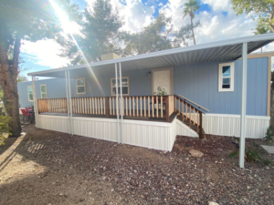 A newly built wooden deck and porch with steps on a mobile home, showcasing handyman work by Antoine Grisby Construction in Gilbert, AZ.