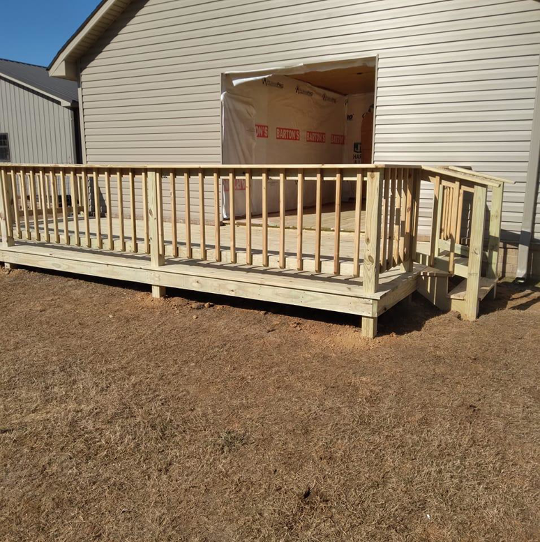 A newly built wooden deck and railing attached to a house by Payne's Cleaning and Handyman Services in Jonesboro, AR.