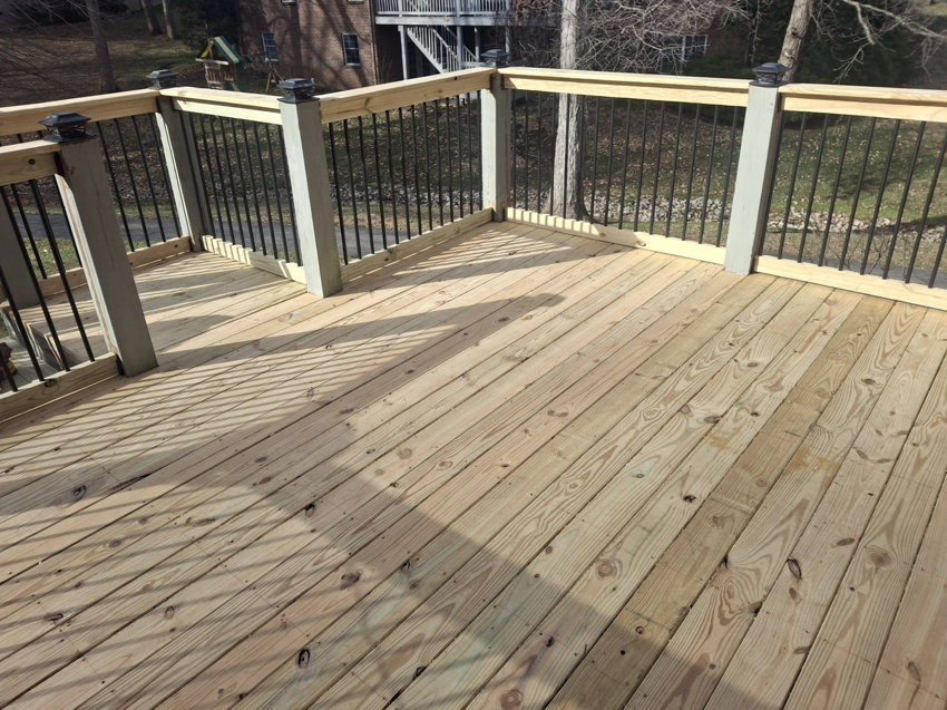 A newly built wooden deck surface with railings by American Renovation Llc in Fairplay, SC.
