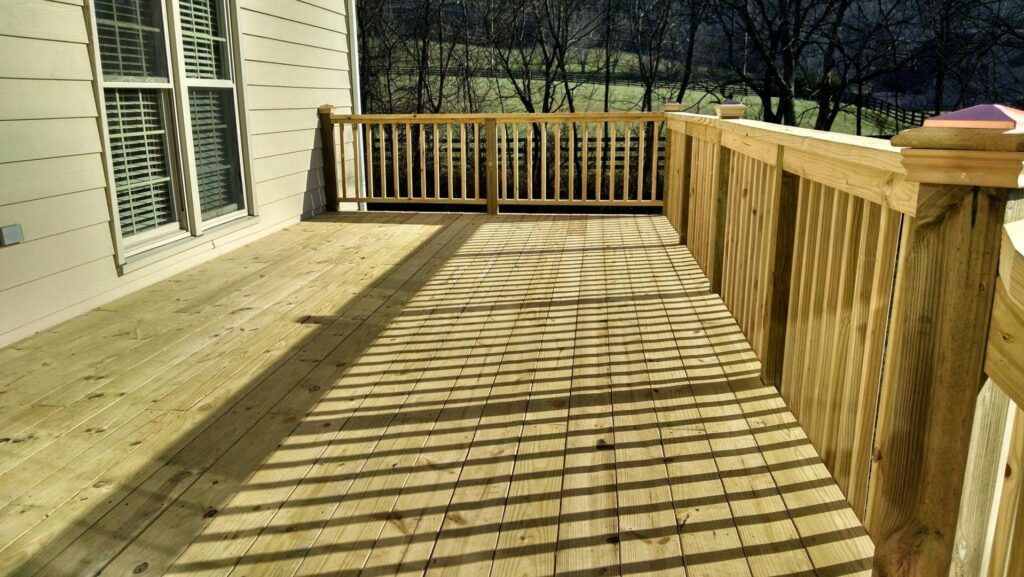 A newly built wooden deck with railings, showcasing quality craftsmanship by Unique Construction Services in Knoxville, TN