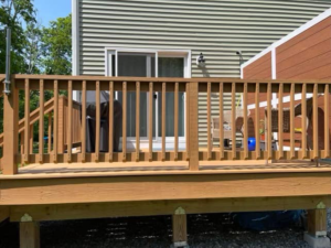 A newly built wooden deck with sturdy railings by Friendly Neighborhood Handyman in Uxbridge, MA.