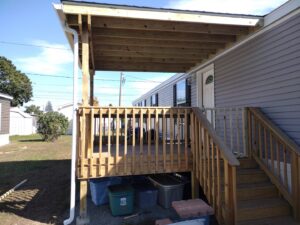 A newly built wooden deck with a protective roof attached to a mobile home by Brothers Home Improvement in East Hartford, CT