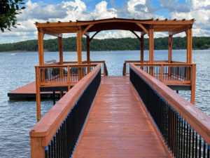 A newly built wooden dock and pergola structure over a lake by A.G Deck & Painting in Charlotte, NC.