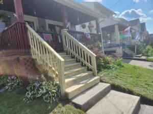 Newly built wooden front porch stairs and railing by Indoor/Outdoor Home Repairs in Parma, OH.
