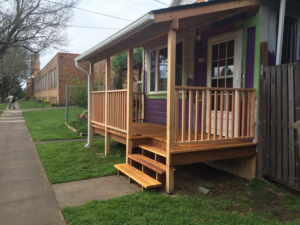 A newly built wooden front porch with steps and railings, completed by Fine Hand LLC in Portland, OR