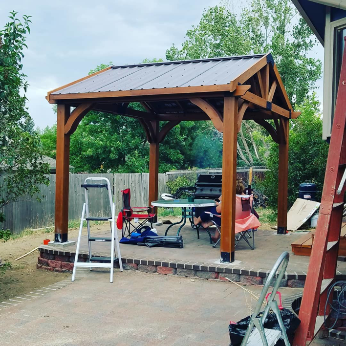 A newly built wooden gazebo with a metal roof on a brick patio, completed by Steveson Enterprises, Inc. in Golden, CO.