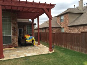 A newly built wooden pergola over a stone patio, showcasing general contractor work by Texas Wounded Veterans Builders and Contractors in McKinney, TX.