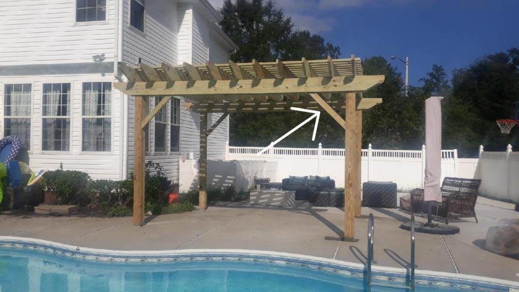 A newly built wooden pergola installed poolside by Signature Deck & Pergola in Virginia Beach, VA