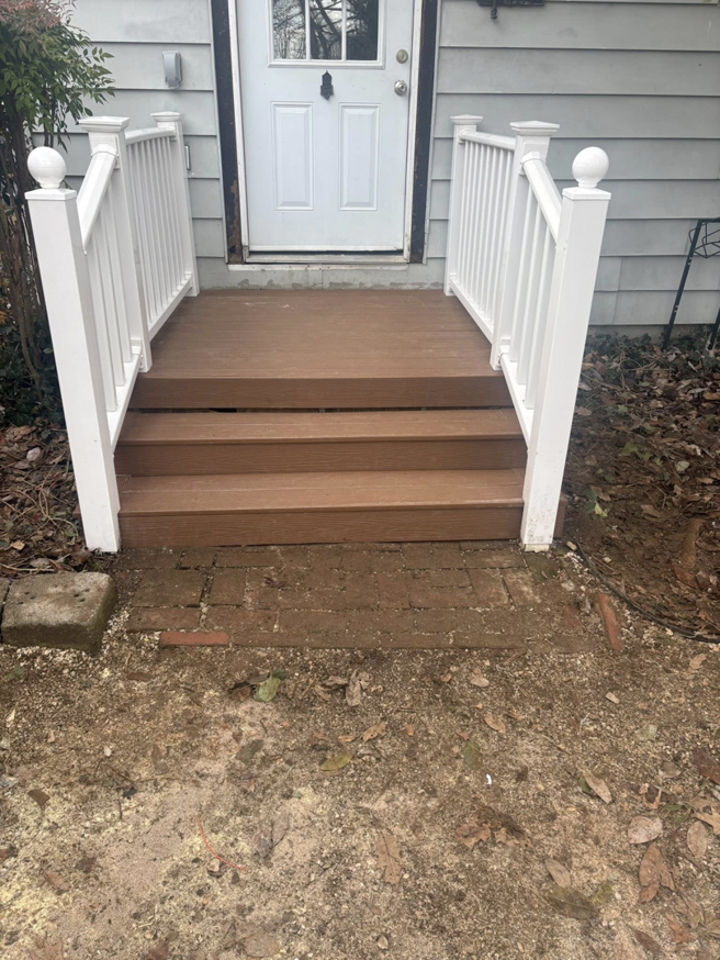 A newly built brown wooden porch with white railings and steps by Savage Home Builders in Hodgenville, KY