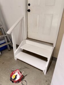 Newly built wooden steps and a handrail installed next to a door by Handy Fix Co. in Cleveland, OH.