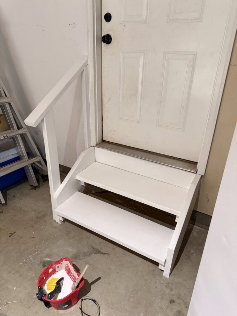 Newly built wooden steps and a handrail installed next to a door by Handy Fix Co. in Cleveland, OH.