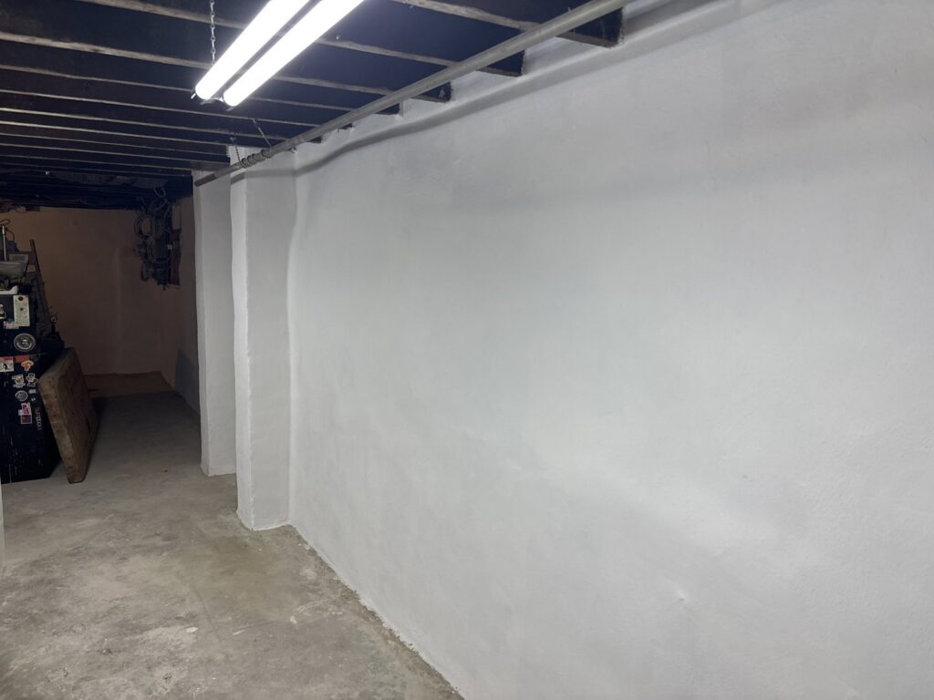 A newly coated basement wall, showcasing waterproofing work by Foundation Repair and Waterproofing in Philadelphia, PA.