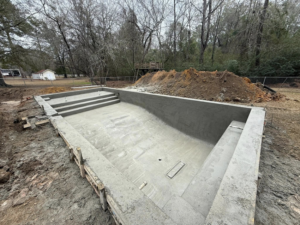 A newly constructed concrete pool shell with steps, ready for finishing by Ga Impact Shotcrete in Atlanta, GA.