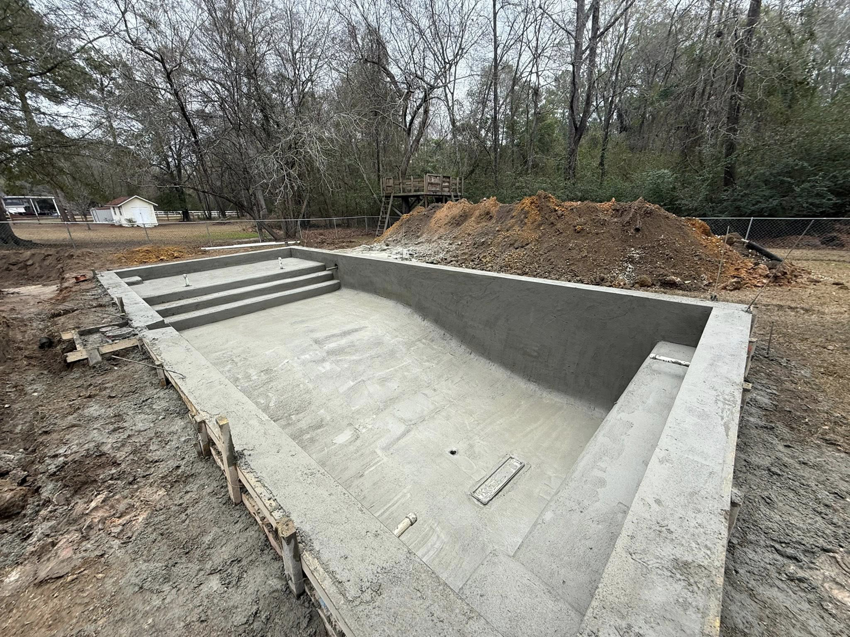 A newly constructed concrete pool shell with steps, ready for finishing by Ga Impact Shotcrete in Atlanta, GA.