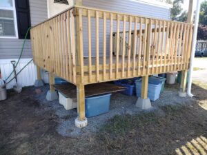 A newly constructed wooden deck with railings and support posts by Brothers Home Improvement in East Hartford, CT