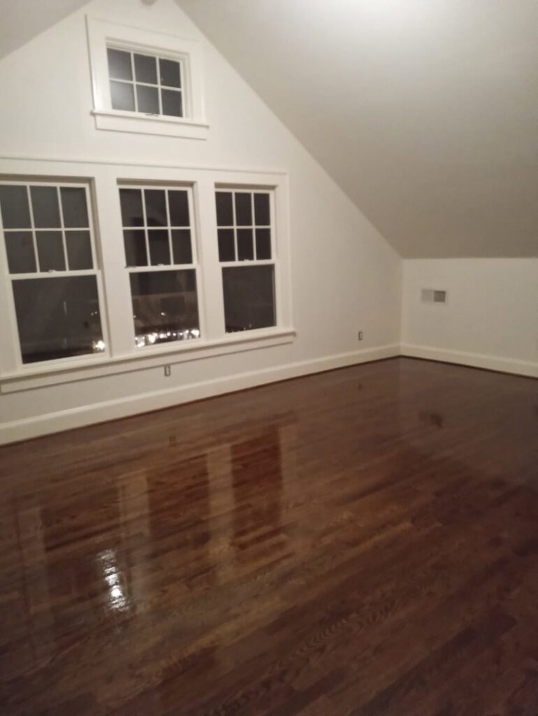 A room showcasing a newly finished and shiny dark hardwood floor by Glenni Floors LLC in Roswell, GA.