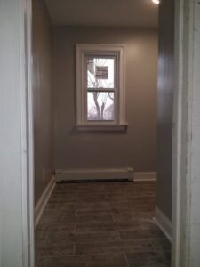 A newly finished room with light gray walls and wood-look tile flooring by Brothers Home Improvement in East Hartford, CT