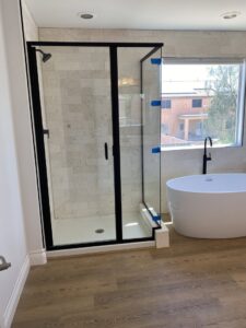 A newly installed black-framed shower door and freestanding tub by Cohaco Building Specialties, a handyman service in Peoria, AZ.