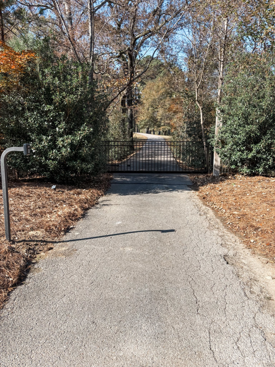 A newly installed black metal driveway gate by Swift Fencing Co. in Birmingham, AL.