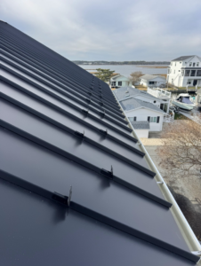 A newly installed black metal roof with snow guards, completed by Bayside Exteriors in Lewes, DE.