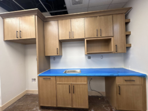Newly installed light wood cabinets, sink, and blue-wrapped countertop by Capitol Construction and Roofing LLC in Raleigh, NC
