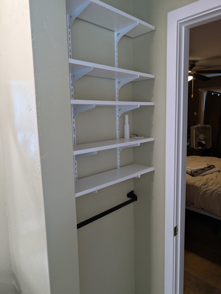 Newly installed white closet shelving and hanging rod by A&A Property Renovations LLC in Green Bay, WI.