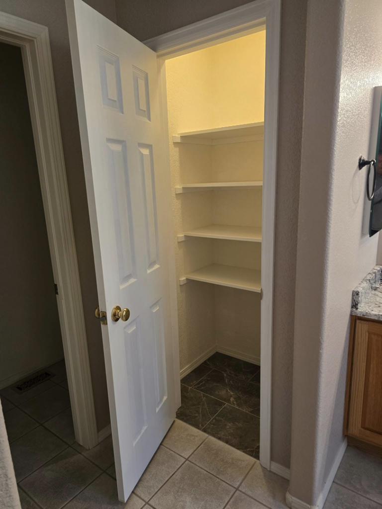Newly installed white shelving in a closet or pantry by Next Level Finish, providing organization solutions in Fort Collins, CO.