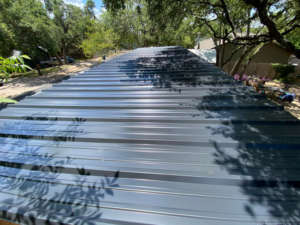 A newly installed dark grey metal roof on a building, completed by J&J ultimate roofing llc in Austin, TX