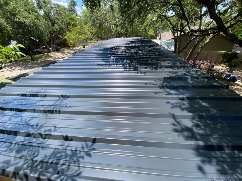 A newly installed dark grey metal roof on a building, completed by J&J ultimate roofing llc in Austin, TX