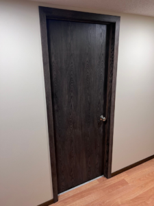 A newly installed dark wood interior door and matching trim by M.R. Renovations, LLC in Maple Grove, MN.