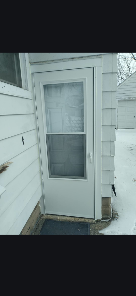 A newly installed white exterior door and screen door by Helping Handyman Fox Valley LLC in Oshkosh, WI.
