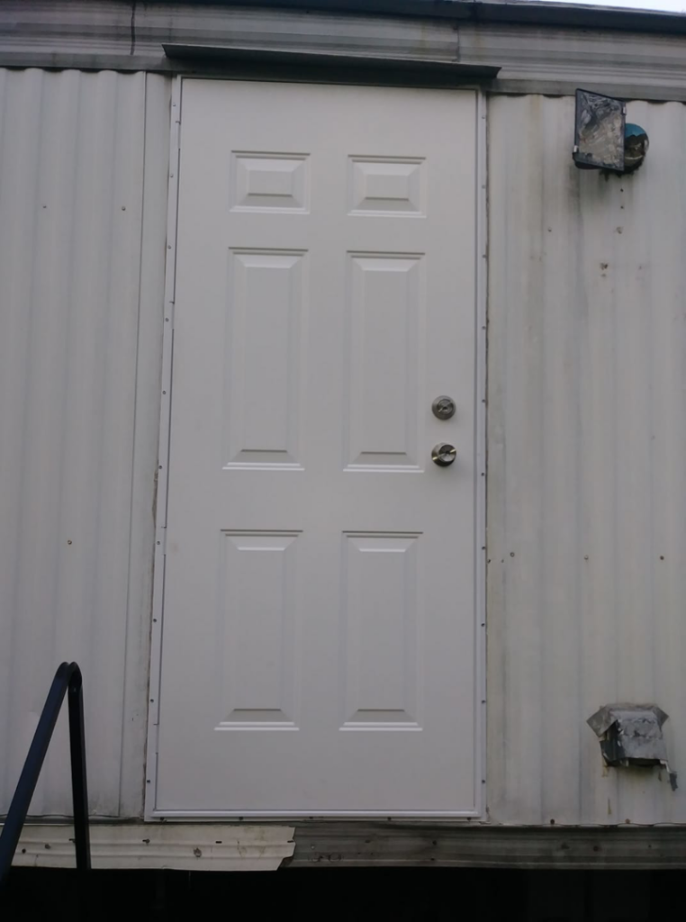 A newly installed white exterior door on a mobile home by Home Solutions of Kansas City in Kansas City, MO