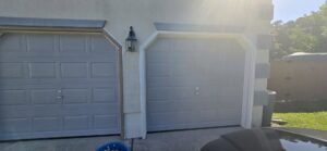 Two newly installed or painted garage doors on a residential property by WHE Construction in Virginia Beach, VA